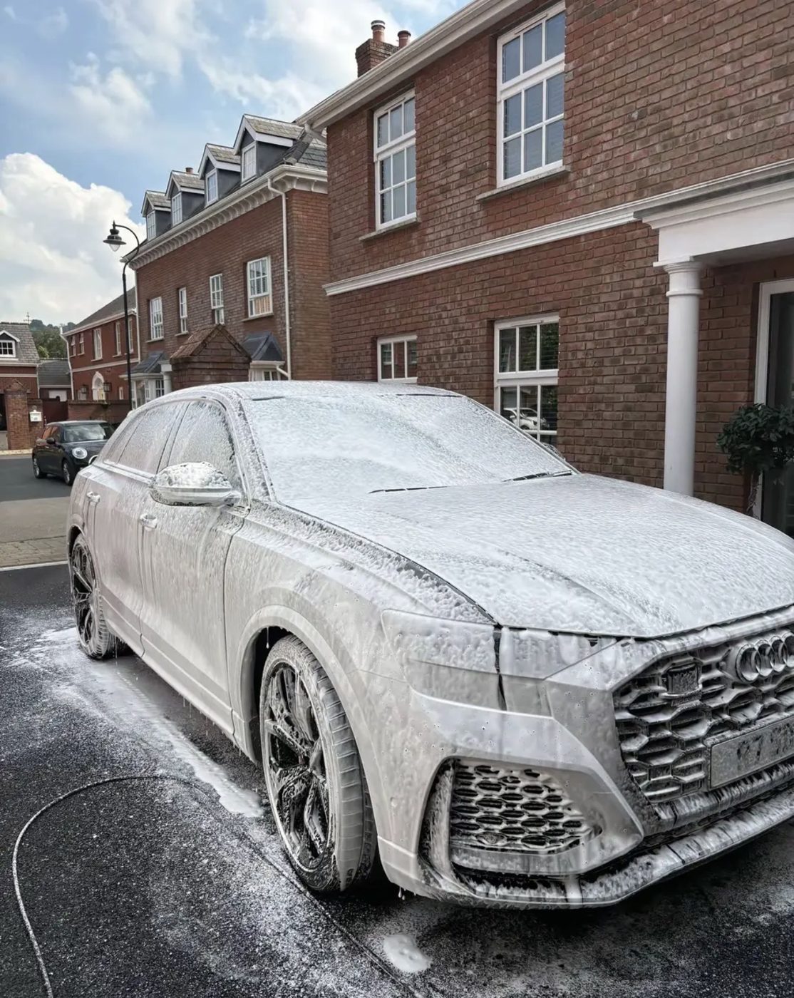 Audi RS Q8 covered in snow foam during a wash